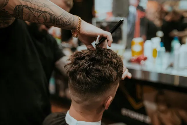 Kapster memotong bagian atas rambut bertekstur dengan gunting